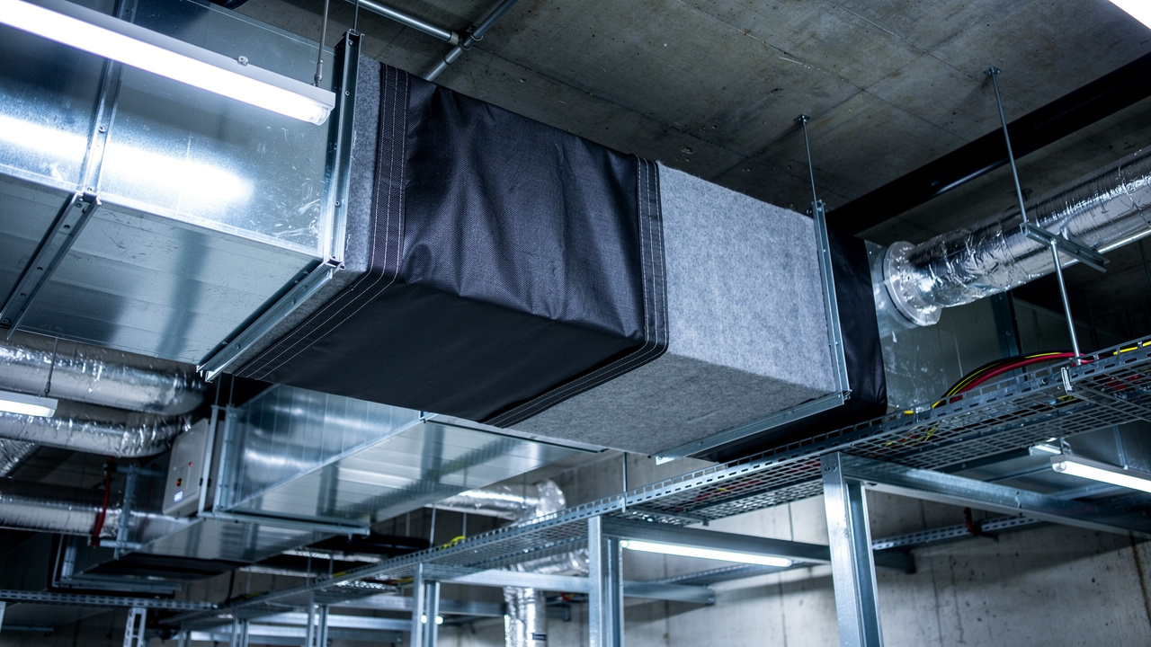 HVAC duct wrapped with MLV acoustic barrier in mechanical room